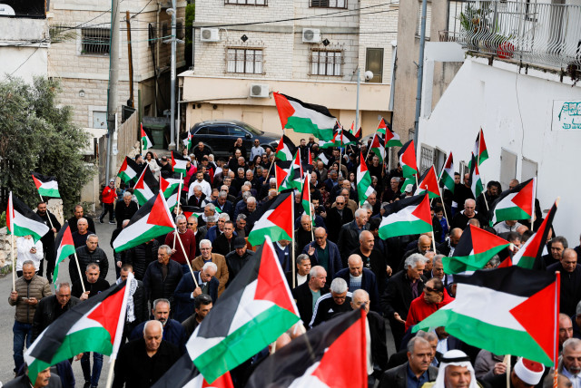  Israeli Arabs hold Palestinian flags as they take part in a ''Land Day'' rally, an annual commemoration of the killing of six Arab citizens by Israeli security forces in 1976 during protests against land confiscations, in Sakhnin in northern Israel March 30, 2023.  (credit: REUTERS/AMMAR AWAD)