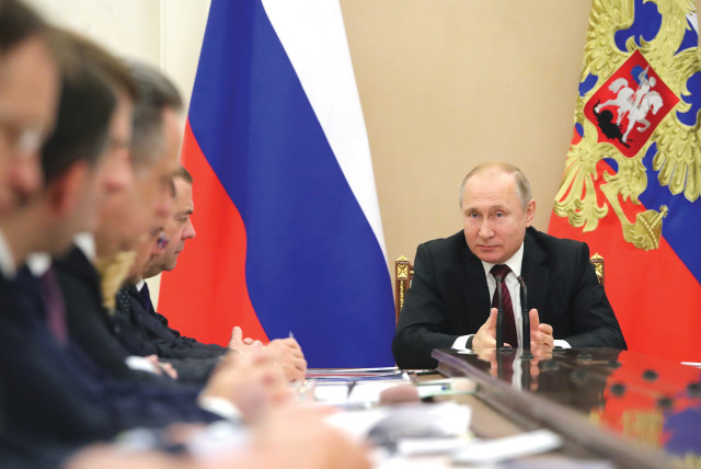 RUSSIA’S PRESIDENT Vladimir Putin chairs a meeting with members of the government at the Kremlin, last month. He has claimed that the economy has shrugged off the sanctions. (photo credit: Sputnik/Kremlin/Reuters)