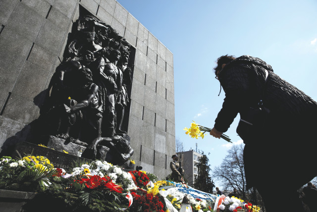  A WOMAN LAYS daffodils during the commemoration of the 78th anniversary of the Warsaw Ghetto Uprising, in front of the Warsaw Ghetto monument in 2021.  (credit: KACPER PEMPEL/REUTERS)