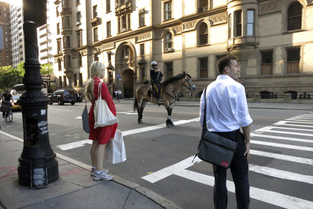  A policeman on a horse waits at a traffic light in the Upper West Side neighbourhood of New York June 20, 2013. (credit: GARY HERSHORN/REUTERS)