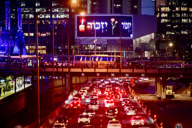 People stand as one minute siren sounded across Israel, marking Remembrance Day on Ayalon highway, Tel Aviv, April 24, 2023. (credit: AVSHALOM SASSONI/FLASH90)