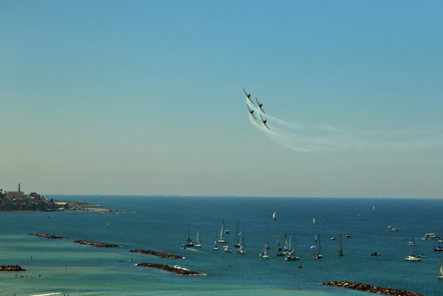 Sail boats and yachts watch from the water as Israeli Air Force fighter jets fly over Tel Aviv in the center of the country as part of Israel's Independence Day airshow, in this photo taken from the rooftop of the Carlton Hotel in Tel Aviv, April 26, 2023.  (credit: ORI LEWIS)
