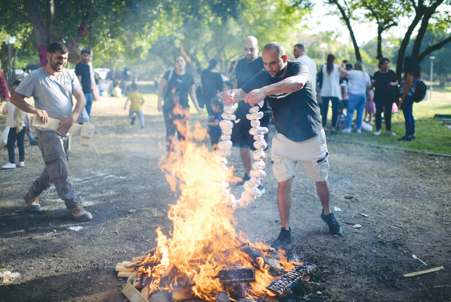  CHILDREN AND their parents gather around a bonfire to celebrate Lag Ba’omer last year, in Tel Aviv. ‘We thought it was time to resurrect the holiday and make it relevant for our community,’ says the writer.  (credit: TOMER NEUBERG/FLASH90)