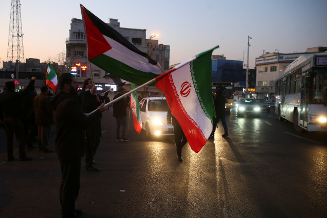  People hold a Palestinian and Iranian flags as they celebrate in the street after Iran launched missiles at U.S.-led forces in Iraq, in Tehran, Iran January 8, 2020.  (credit: NAZANIN TABATABAEE/WANA VIA REUTERS)