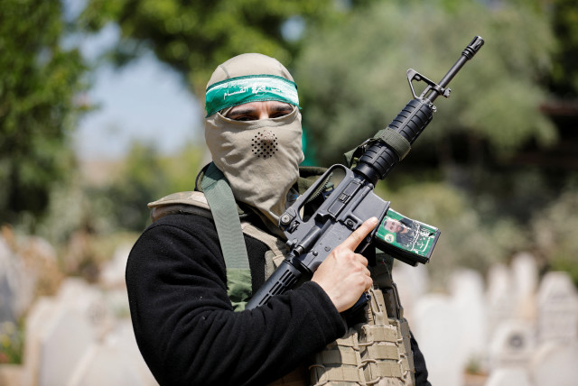  A person holds up a gun during the funeral of two Palestinian Islamic Jihad gunmen who were killed in an Israeli raid, in Jenin refugee camp in the West Bank May 10, 2023. (credit: RANEEN SAWAFTA/REUTERS)