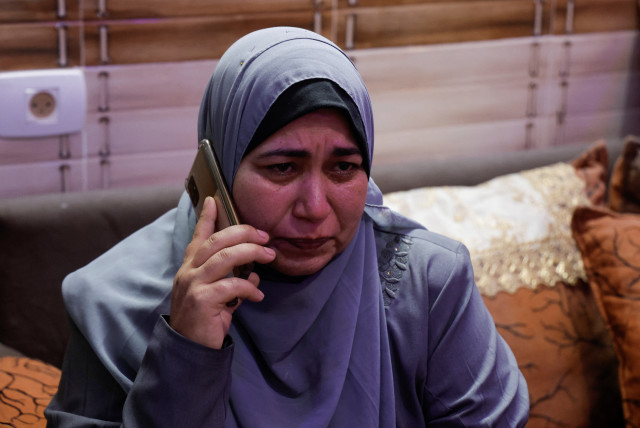 Asmahan, the mother of Palestinian woman Dania Adas, who was engaged to Mohammad Saed and killed in a nearby Israeli strike that damaged their house, reacts as she speaks on a phone inside the house in Gaza City May 10, 2023. (credit: MOHAMMED SALEM/REUTERS)