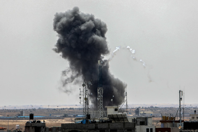  Smoke rises above buildings After air strikes by Israeli warplanes, in the southern Gaza Strip, on May 12, 2023.  (photo credit: ABED RAHIM KHATIB/FLASH 90)