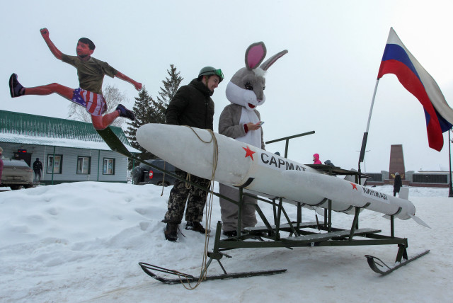 Participants stand next to a sled, which is composed of various parts including elements depicting Ukraine's President Volodymyr Zelenskiy and Russian missiles Kinzhal and Sarmat (credit: REUTERS/ALEXEY NASYROV)