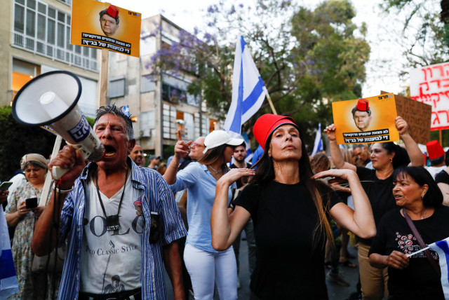  People demonstrate in support of the judicial overhaul, near the home of Aharon Barak, former president of the Supreme Court, in Tel Aviv on May 4.  (credit: CORINNA KERN/REUTERS)