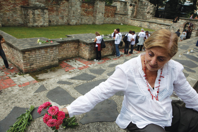  PLACING FLOWERS at the site where a synagogue was set aflame in 1941, during a Holocaust commemoration in Riga, July 4, 2011. (credit: Ints Kalnins/Reuters)