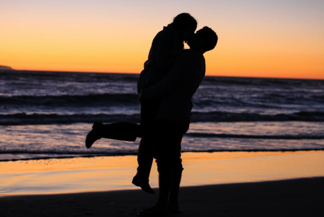  A young couple kissing at the beach during a sunset. (credit: FREERANGE STOCK)