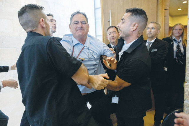  HIZKY SIVAK of the Emek Hefer Regional Council is removed by security personnel from a stormy meeting and vote at the Knesset Finance Committee on the Arnona Fund, last Monday. (credit: YONATAN SINDEL/FLASH90)