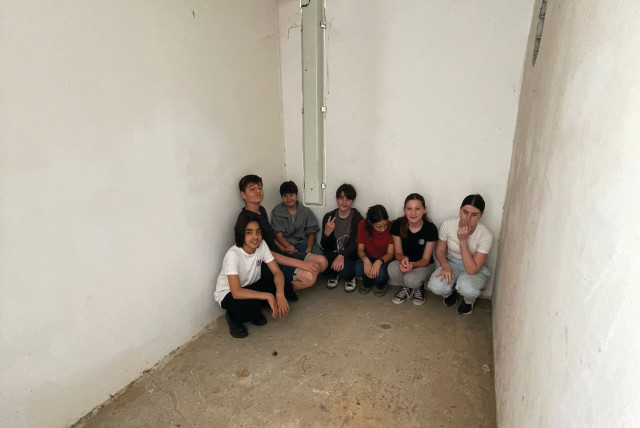 STUDENTS AT Kfar Silver demonstrate how they huddle in a safe room at the youth village when a siren sounds. (credit: WORLD ORT)