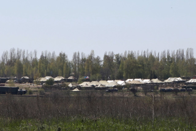  Russian military vehicles and army tents are seen in a field outside the village of Severny in Belgorod region near the Russian-Ukrainian border, April 25, 2014 (credit: REUTERS/SERGEI KHAKHALEV)