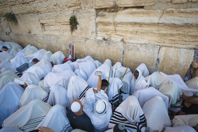  AFTER COVERING their heads with ‘tallitot,’ the Kohanim raise their hands to bless the congregation (Pictured: On Sukkot at the Western Wall)