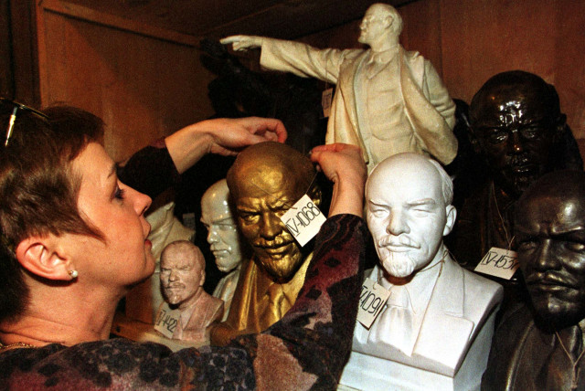  AN EXPERT at The State Museum of Political History of Russia in St. Petersburg adjusts a tag on a bust of Bolshevik leader Vladimir Lenin. Some Jews in the book used art to try to promote their Soviet bonafides. (photo credit: REUTERS)