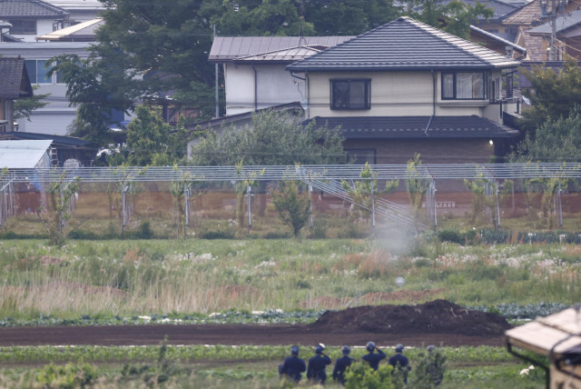 Police officers surround the scene of a stabbing and shooting incident in Nakano, Nagano Prefecture, central Japan, in this photo taken by Kyodo on May 26, 2023. Picture taken with a telephoto lens through obstacles.  (credit: KYODO/VIA REUTERS)