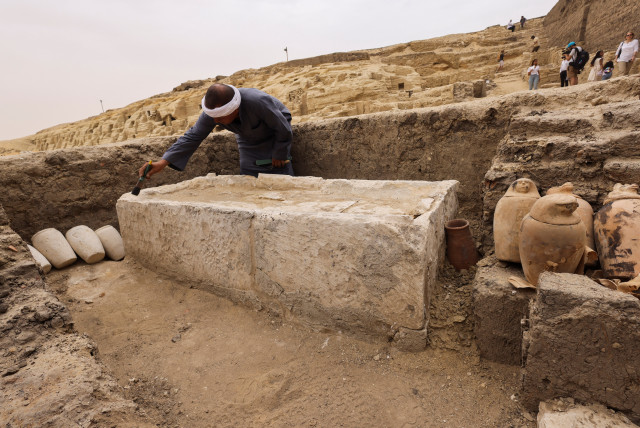  A worker brushes off the dust at the embalming workshop site for humans at the newly discovered site where two embalming workshops for humans and animals, two tombs and a collection of artefacts were also found, near Egypt's Saqqara necropolis, in Giza, Egypt May 27, 2023 (credit: REUTERS/AMR ABDALLAH DALSH)