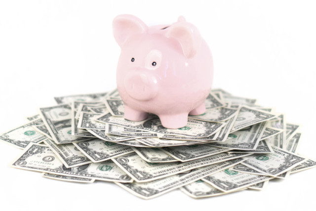  Illustrative image of a piggy bank on a pile of money. (photo credit: WISCONSIN PUBLIC RADIO)