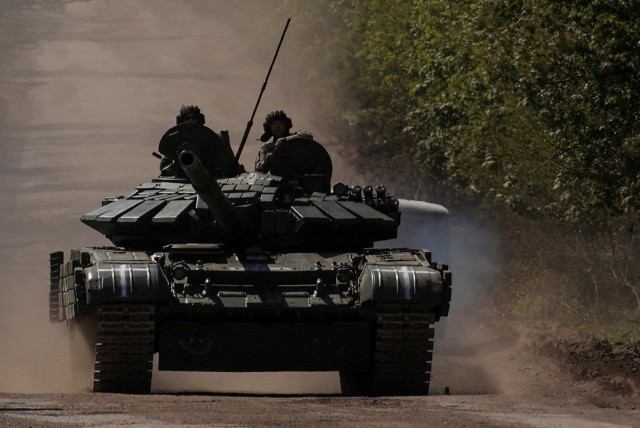  Ukrainian servicemen ride atop of a tank on a road to the frontline town of Bakhmut, amid Russia's attack on Ukraine, in Donetsk region, Ukraine May 12, 2023.  (credit: REUTERS/Sofiia Gatilova/File Photo)