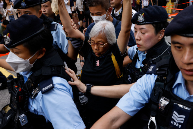  Police detain a woman in downtown on the 34th anniversary of the 1989 Beijing's Tiananmen Square crackdown, near where the candlelight vigil is usually held, in Hong Kong, China June 4, 2023. (credit: TYRONE SIU/ REUTERS)