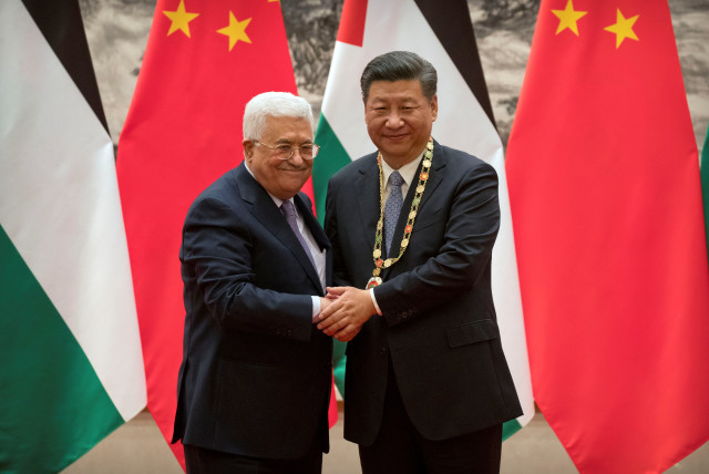  Palestinian President Mahmoud Abbas, left, shakes hands after presenting a medallion to Chinese President Xi Jinping, right, during a signing ceremony at the Great Hall of the People in Beijing, China, July 18, 2017. (credit: REUTERS/MARK SCHIEFELBEIN/POOL)