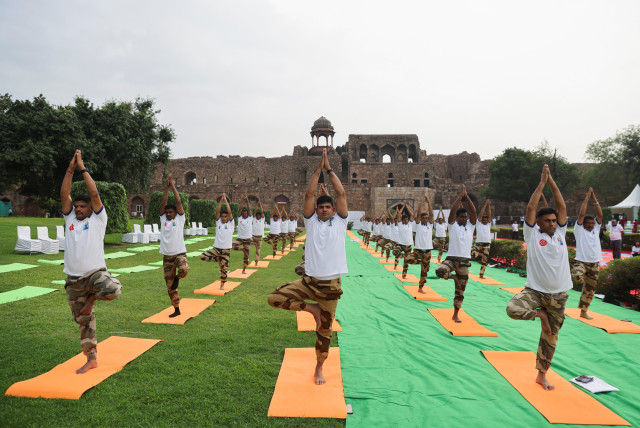  People pose for the camera as they perform yoga on International Yoga Day at Purana Qila, or Old Fort in New Delhi, India, June 21, 2023. (credit: REUTERS/ANUSHREE FADNAVIS)