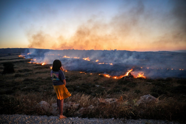  A field fire during clashes between Palestinians and Jewish settlers near the Palestinian village of Qusra, in the West Bank, June 22, 2023 (credit: FLASH90)