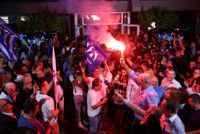  Supporters react as the New Democracy conservative party leader Kyriakos Mitsotakis speaks outside the party's headquarters, after the general election, in Athens, Greece, June 25, 2023. (credit: REUTERS/STOYAN NENOV)