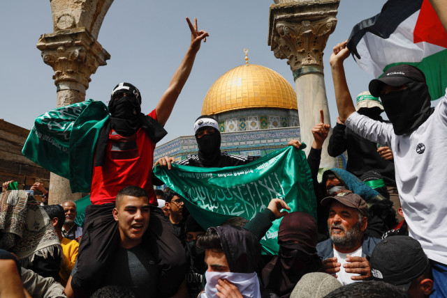  Palestinians demonstrate at Al-Aqsa Mosque as Palestinian Muslims attend Friday prayers of the Muslim holy month of Ramadan, on the compound known to Muslims as the Noble Sanctuary and to Jews as the Temple Mount, in Jerusalem's Old City, April 7, 2023. (credit: AMMAR AWAD/REUTERS)