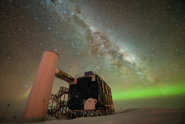  The IceCube Lab is seen under a starry, night sky, with the Milky Way appearing over low auroras in the background. (credit: Yuya Makino, IceCube/NSF)