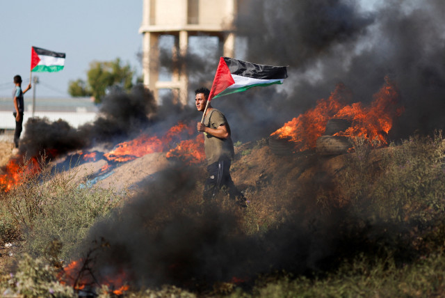  Palestinians protest against Israeli army raid in Jenin, along Israel-Gaza border fence east of Gaza City July 3, 2023 (photo credit: REUTERS/MOHAMMED SALEM)
