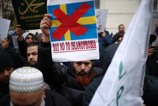 A man displays a placard during a protest following the burning of the Koran in Stockholm, outside the embassy of Sweden in London, Britain, January 28, 2023.  (photo credit: REUTERS/HENRY NICHOLLS)