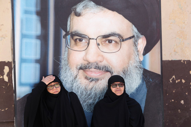  Women sit near a picture of Lebanon's Hezbollah leader Sayyed Hassan Nasrallah, during an event marking the commemoration of Israel's withdrawal from southern Lebanon in 2000, at the former Khiam prison, in Khiam village, southern Lebanon, May 25, 2023 (credit: AZIZ TAHER/REUTERS)