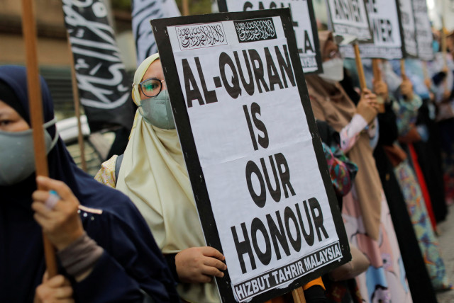  A woman holds a placard that reads '' Al-Quran is our honour'' during a protest in front of the Swedish embassy after Rasmus Paludan, leader of Danish far-right political party Hard Line burned a copy of the Koran near the Turkish Embassy in Stockholm, in Kuala Lumpur, Malaysia January 27, 2023. (credit: REUTERS/Hasnoor Hussain)