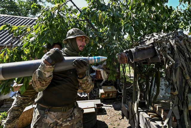  Ukrainian servicemen load a shell into a Partyzan small multiple rocket launch system before firing toward Russian troops at a position near a front line, amid Russia's attack on Ukraine, in Zaporizhzhia region, Ukraine July 13, 2023. (credit: REUTERS/STRINGER)
