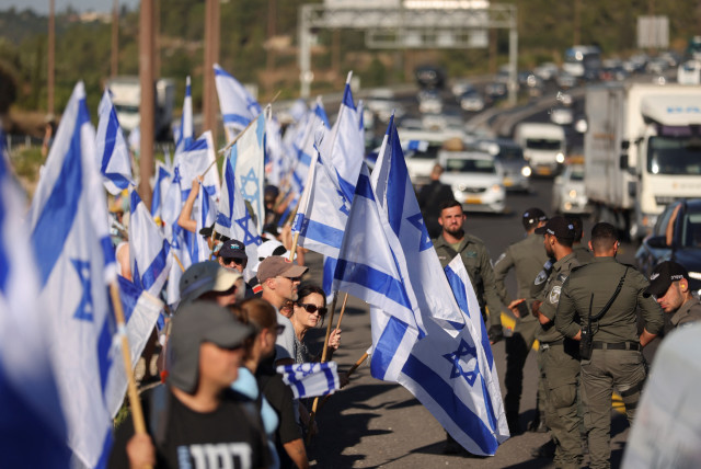  People demonstrate on the 'Day of National Resistance' in protest against Israeli Prime Minister Benjamin Netanyahu and his nationalist coalition government's judicial reform, on a highway leading to Jerusalem July 18, 2023.  (credit: RONEN ZVULUN/REUTERS)