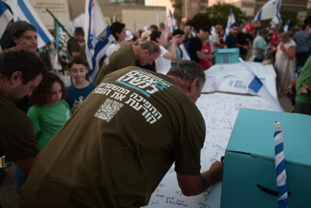  IDF reservists sign letters stating they will no longer show up for reserve service in light of the government's judicial reform plan. July 18, 2023 (credit: AVSHALOM SASSONI)