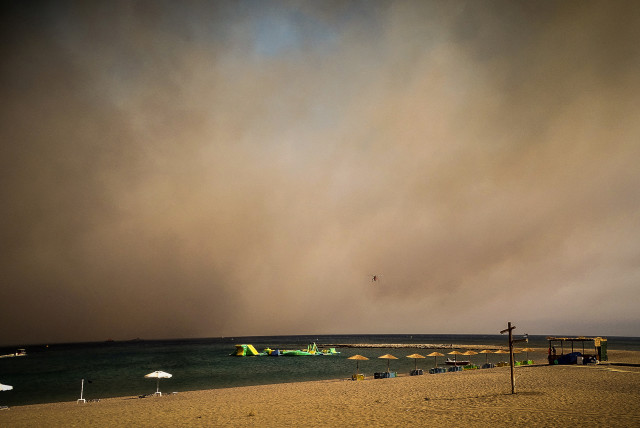  A beach is seen covered in smoke during a wildfire on the island of Rhodes, Greece, July 22, 2023. (credit: REUTERS)