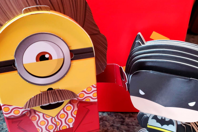 Batman and Minions toys made from paper and cardboard that children assemble themselves are seen, as McDonald's makes its future Happy Meal toys for kids more sustainable, in New York, U.S. September 20, 2021. (credit:  REUTERS/Hilary Russ)