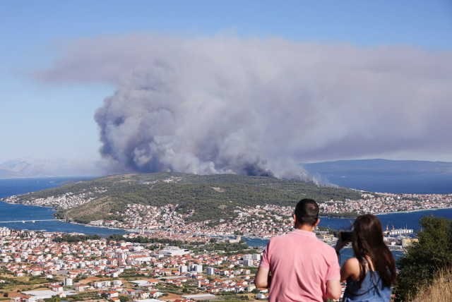  People watch the wildfire on the island Ciovo, from Seget Gornji, Croatia, July 27, 2023. (credit: ANTONIO BRONIC/REUTERS)
