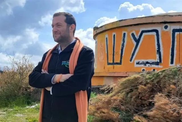 Samaria Regional Council head Yossi Dagan on the Homesh hilltop with its iconic water tower painted orange, the color of the anti-disengagement protesters. (credit: SAMARIA REGIONAL COUNCIL)