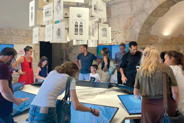  GATHERING AROUND the exhibition’s tablets, which allow users to build their own Jerusalem architecture. (credit: COURTESY TOWER OF DAVID)