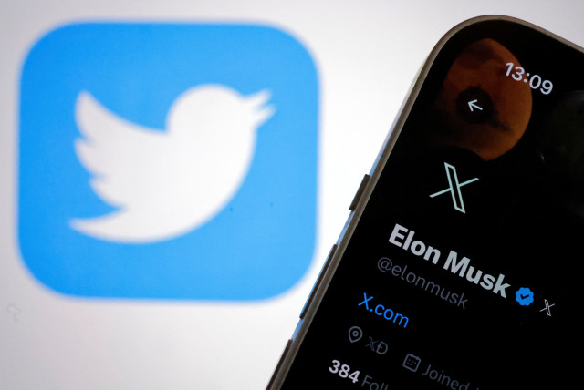  The new logo of Twitter is seen on Elon Musk’s Twitter account on an iPhone as the old Twitter logo is displayed on a MacBook screen in Galway, Ireland July 24, 2023 (credit: REUTERS/CLODAGH KILCOYNE)