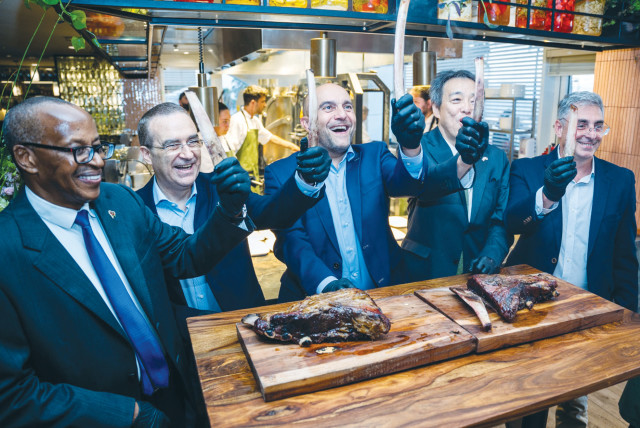  TRIUMPHANT DIPLOMATS hold up the bones they extracted from an 18 kg. skewer of osobuku at the launch of the Flame open-fire restaurant at the Carlton Hotel, Tel Aviv. (credit: Yuri Skvirski)