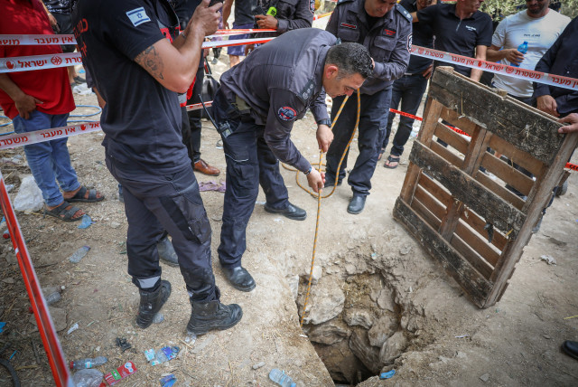  Police and rescue personnel at the scene where three people were injured when they fell into an 8-m deep pit  in the ground in Deir el-Asad, Northern Israel on August 13, 2023 (credit: David Cohen/Flash90)