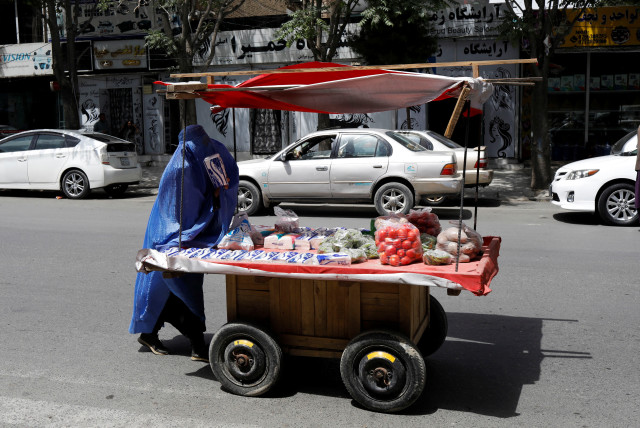  An Afghan woman pushes her cart in Kabul, Afghanistan, July 6, 2023. (credit:  REUTERS/ALI KHARA)
