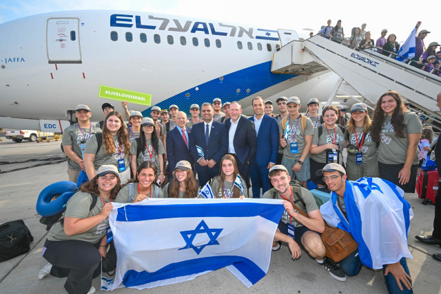  Olim on the 64th Nefesh B’Nefesh charter flight pose with the organization’s co-founders Rabbi Yehoshua Fass and Tony Gelbart; Aliyah and Integration Minister Ofir Sofer; and ministry Director-General Avichai Kahana.  (credit: SHAHAR AZRAN, YONIT SCHILLER)