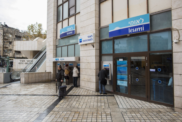  Israelis walks next to Bank Leumi in Jerusalem. (photo credit: YONATAN SINDEL/FLASH90)