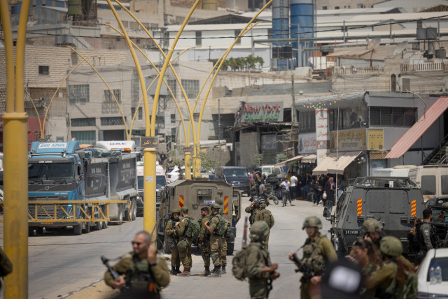  Israeli security forces seen at the entrance to the West Bank city of Hebron, after the deadly shooting attack on Route 60, August 21, 2023. (credit: CHAIM GOLDBEG/FLASH90)